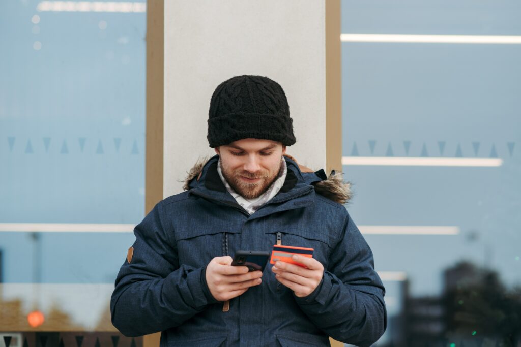 Man happily holding his phone and card