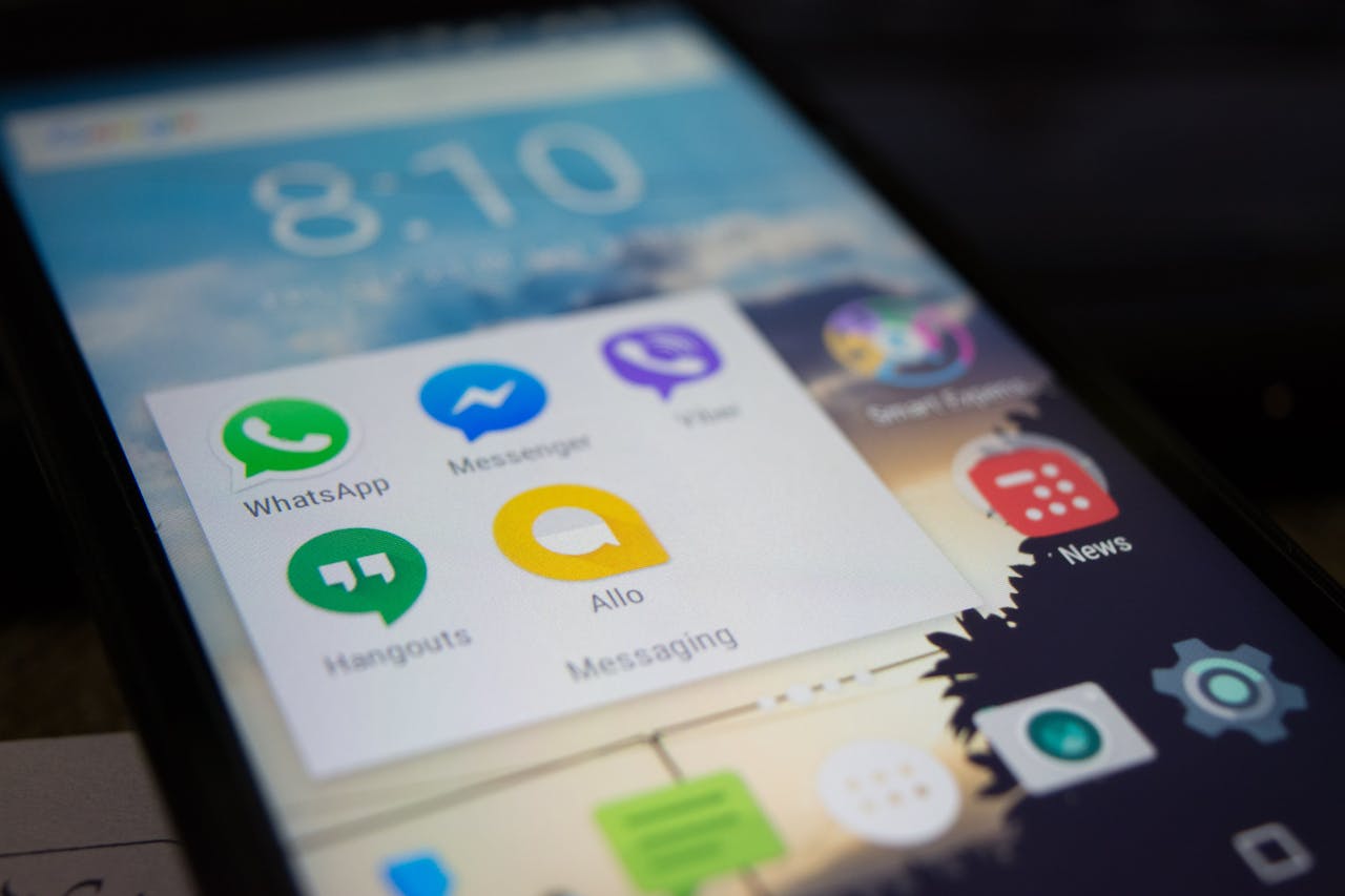Close-up of a smartphone screen displaying popular messaging apps including WhatsApp, Messenger, Viber, Allo, and Hangouts